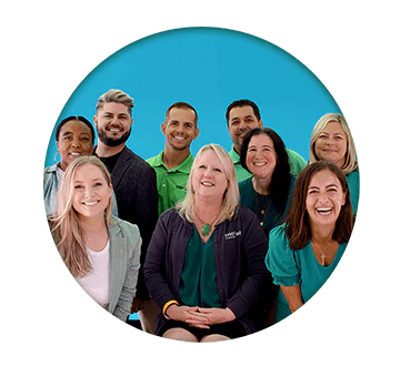 Circle group photo of Cricket Employees on a blue background