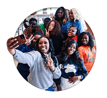 Circle image of college girls posing for a selfie